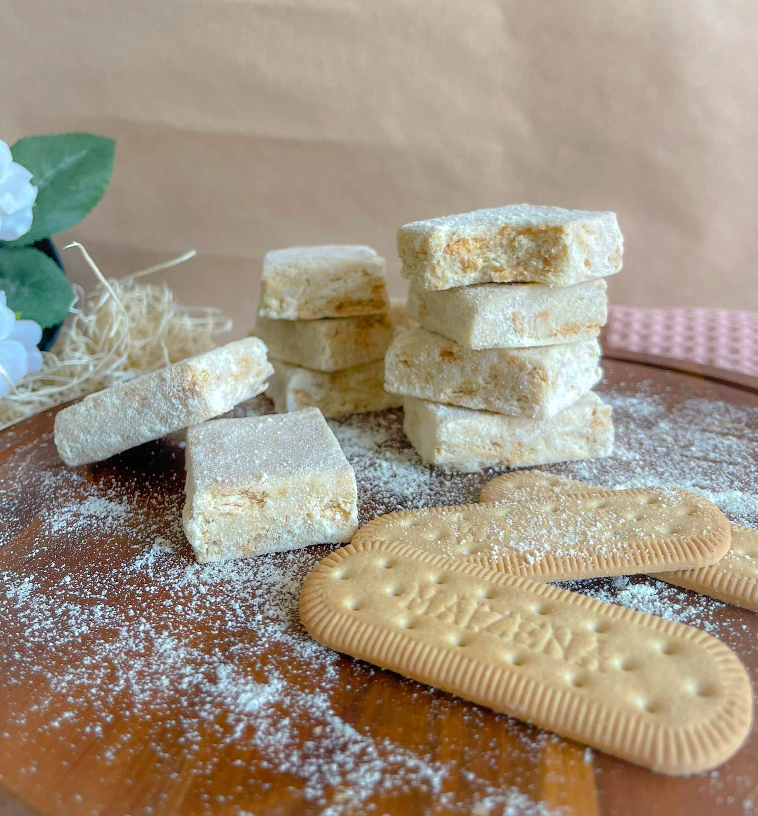 Fudge de maizena empilhado sobre tábua de madeira com biscoitos Maizena