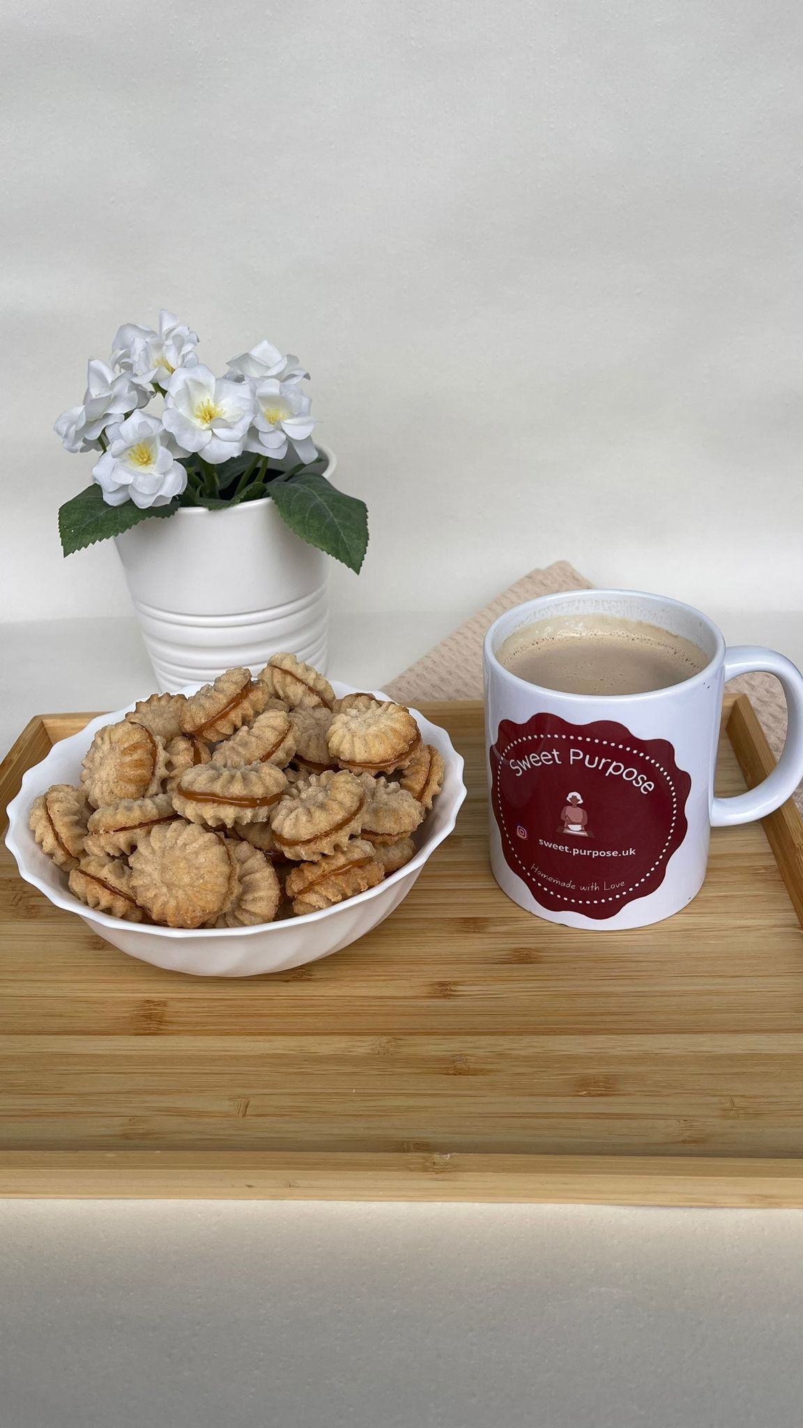 Biscoitos artesanais numa tigela ao lado de caneca Sweet Purpose